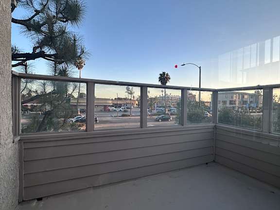 A balcony with a view of a street and buildings at Lido Apartments - 101-197 N Ridgeway, Anaheim, CA