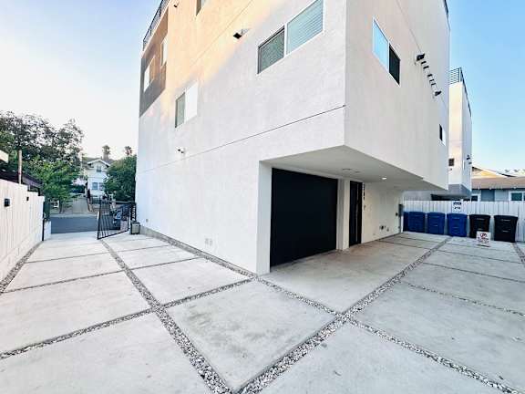 A modern building with a white exterior and a black garage door.