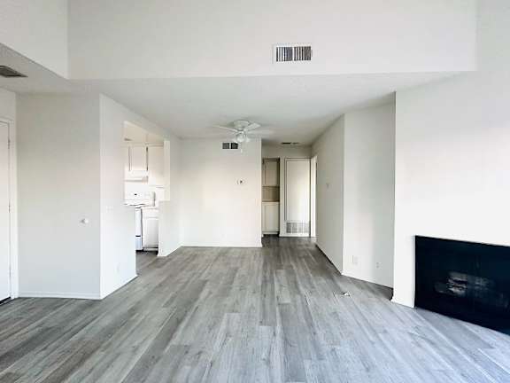 A room with a fireplace and wood flooring.
