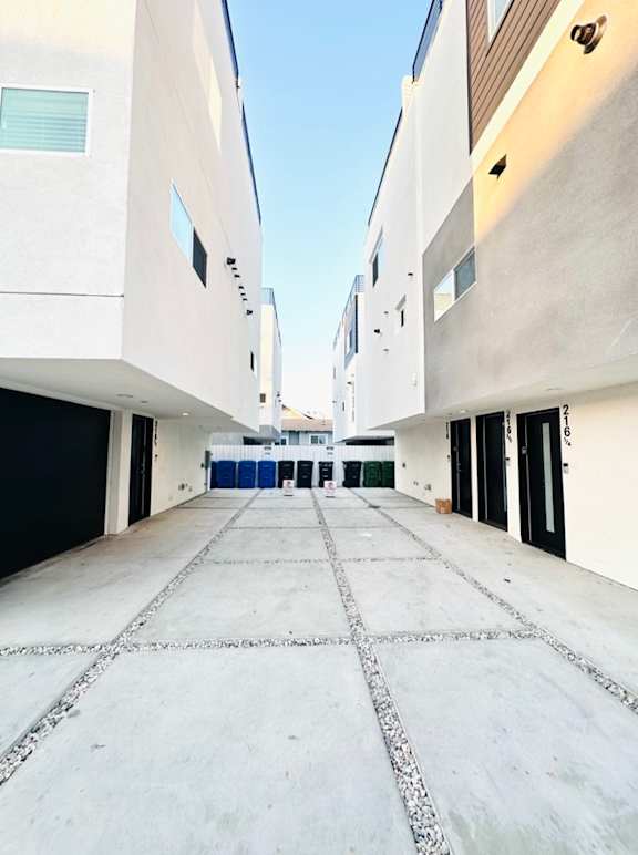 A long, narrow, concrete-floored alleyway between buildings.