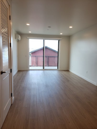 an empty room with a sliding glass door and a red barn in the background at Connect, San Luis Obispo