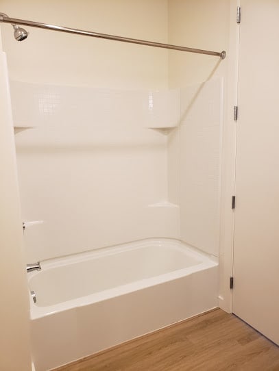 a white bath tub sitting next to a white shower door at Connect, California