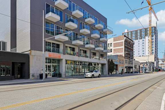 A modern building with a grey facade and a white car parked in front.