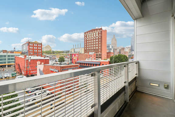 A balcony with a metal railing overlooks a cityscape.