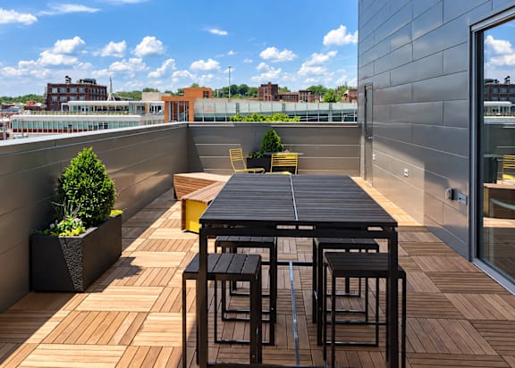 A table and chairs are set on a wooden deck.