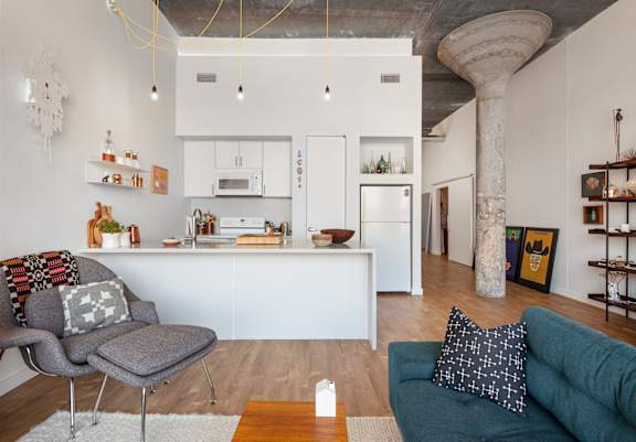 A modern kitchen with white cabinets and a wooden floor.