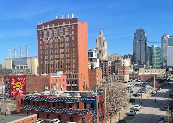 A cityscape with a large building in the foreground and smaller buildings in the background.