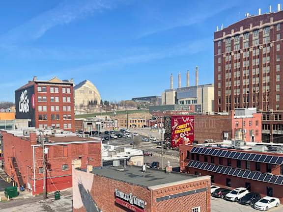 A cityscape with a red building in the foreground and a clear blue sky above.