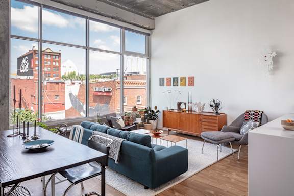 A living room with a view of the city through large windows.