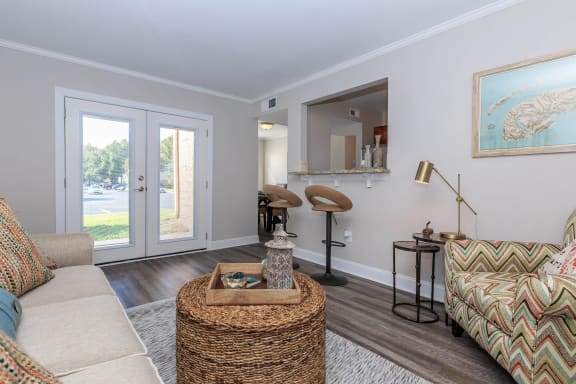 a living room with a couch and a table and a door at Sawgrass Apartments, Charleston, 29412