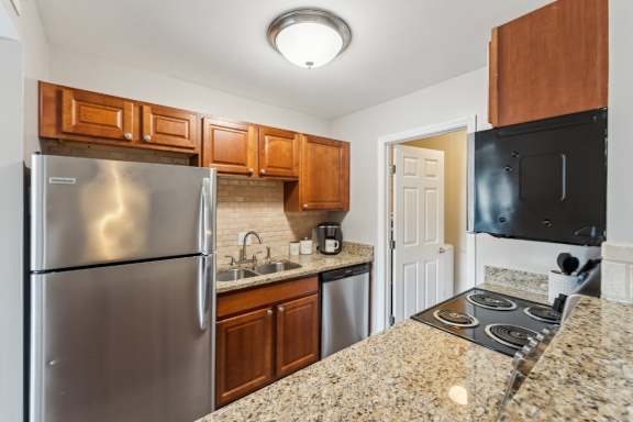A kitchen with granite countertops and stainless steel appliances.