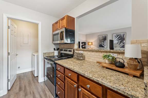 A kitchen with granite countertops and wooden cabinets.