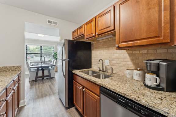 A kitchen with a black refrigerator and wooden cabinets.