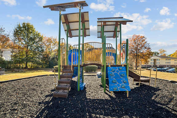 A playground with a blue slide and a brown wooden structure at Lakecrest Apartments, PRG Real Estate Management, Greenville, SC 29615