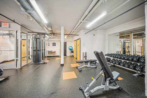 A gym with a variety of equipment including weights and a bench at The Locks, Virginia, 23219