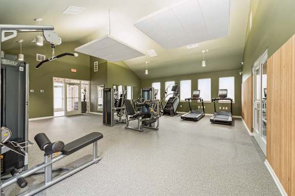 A gym with a variety of equipment at The Courtyards of Chanticleer Apartments, Virginia Beach, VA