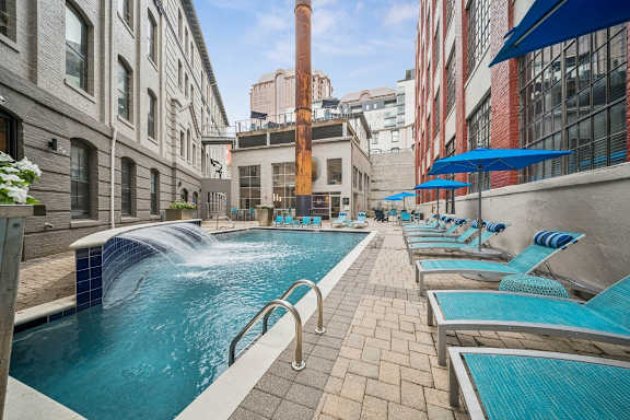 A pool with a waterfall and lounge chairs at The Locks, Virginia, 23219