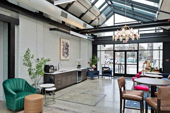 A modern cafe with a green chair and a white table.