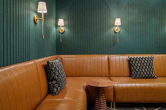 A brown leather couch with a small table in front of it.