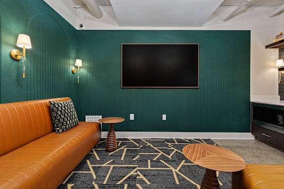 A room with a green wall and a television mounted on it.