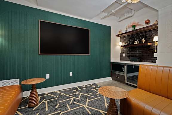 A room with a green wall and a black screen on it.