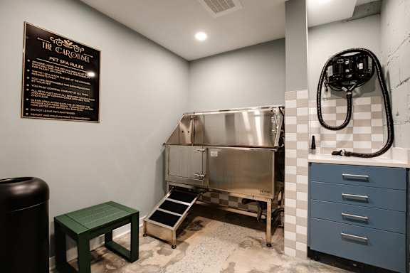 A blackboard menu is on the wall of a room with a stainless steel sink and a green stool at The Carousel, Richmond, Virginia