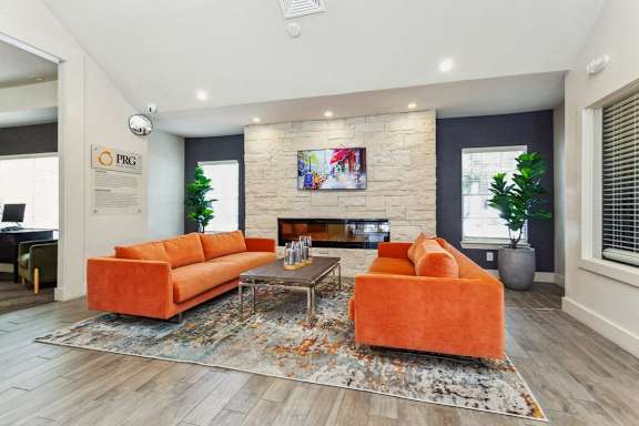 a living room with two orange couches and a fireplace at Palm Crossing, Winter Garden, FL, 34787