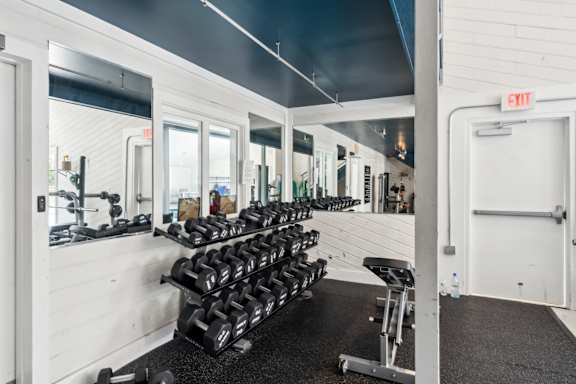 A gym with a row of dumbbells and a bench. at Linkhorn Bay Apartments, Virginia Beach, VA