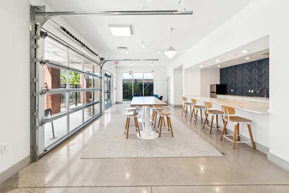 A modern dining room with a long table and chairs.