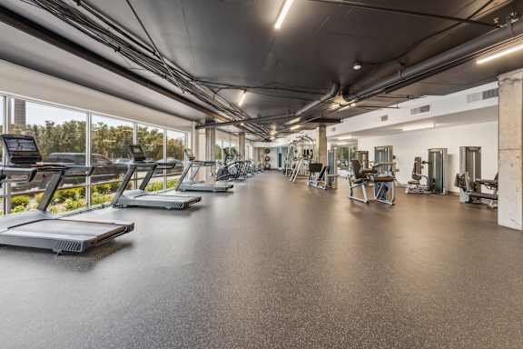 A gym with treadmills and other exercise equipment at The Waterford At Rocketts Landing Apartments, PRG Real Estate, Richmond, VA