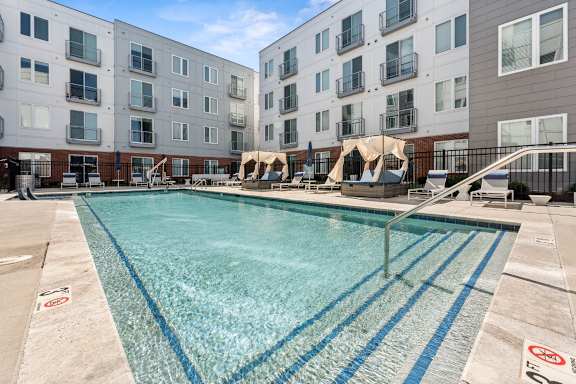 A swimming pool in front of apartment buildings.
