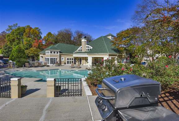 a swimming pool with a house in the background at Beacon Ridge Apartments, PRG Real Estate Management, Greenville, SC 29615