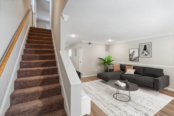 a living room with a staircase and a couch at Lake Johnson Mews, Raleigh, 27606