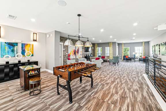 A room with a wooden floor and a pool table at Proximity Apartments, Charleston, SC