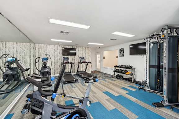 A gym with a variety of equipment including treadmills, stationary bikes, and weight machines.at Chapel View, Chapel Hill, NC 27516