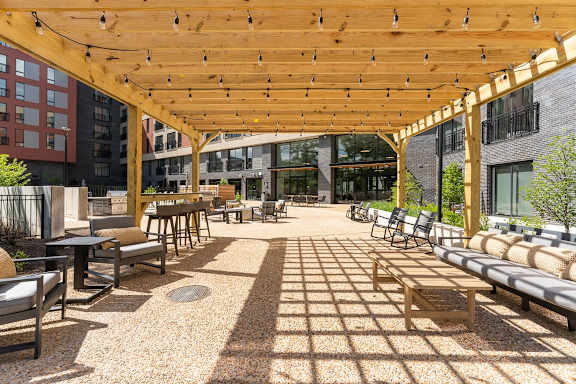 a large patio with chairs and tables under a wooden canopy at Hydro, Richmond, VA
