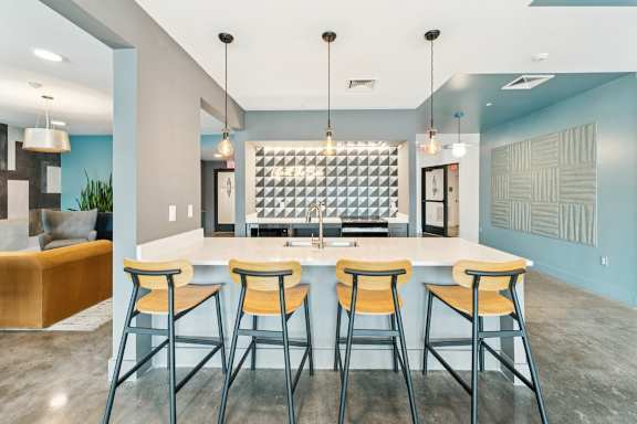 A modern kitchen with a bar area and stools at The Box, Richmond, VA, 23224