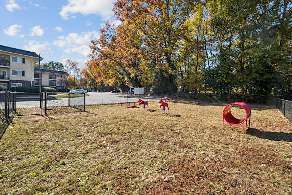 A playground with a red tunnel and two children playing at Lakecrest Apartments, PRG Real Estate Management, Greenville, SC 29615