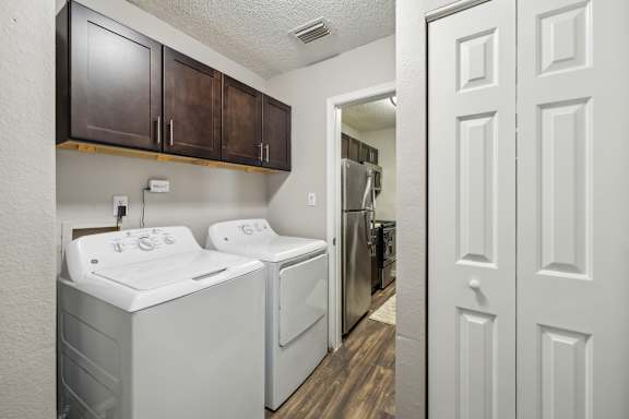 A laundry room with a washer and dryer at The Timbers Apartments, Virginia