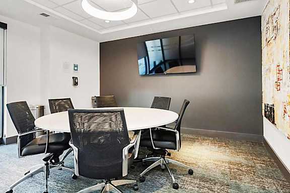 A conference room with a white table and chairs.