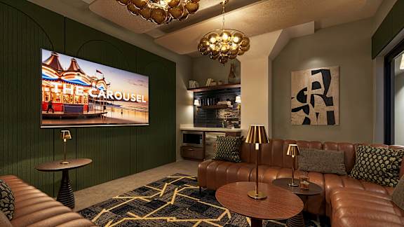 A living room with a brown leather couch and a large screen displaying at The Carousel, Virginia