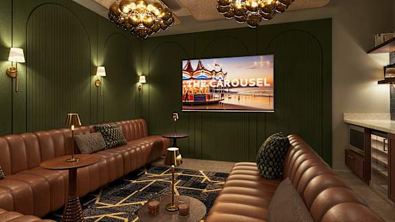 A cinema room with a large screen and a row of seats at The Carousel, Richmond