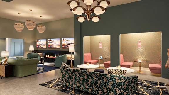 A living room with a green sofa and a chandelier at The Carousel, Virginia