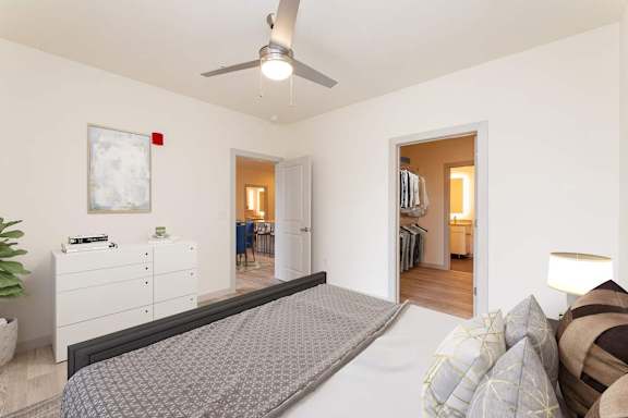 A bedroom with a large bed and a ceiling fan.