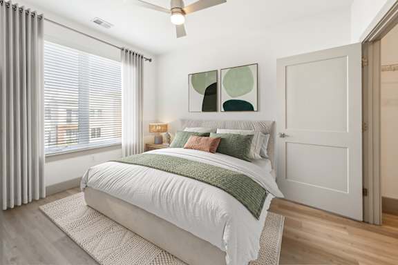 A bedroom with a large bed and a ceiling fan at The Point Apartments on 38th, Virginia, 23508