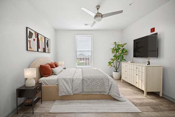 A bedroom with a bed, a ceiling fan, and a television at Circ Apartments, Virginia