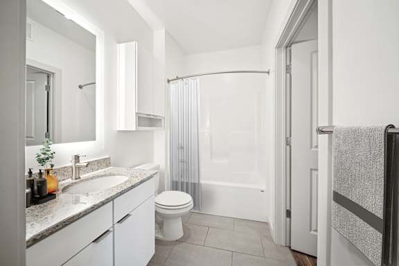 A white bathroom with a toilet, sink, and shower at Circ Apartments, Virginia