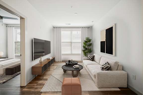 A modern living room with a large couch, a flat screen TV, and a coffee table at Circ Apartments, Virginia