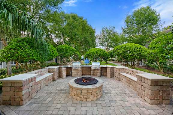 Outdoor fire pit with stone seating and built in grills at Citrus Tower Apartments, Florida