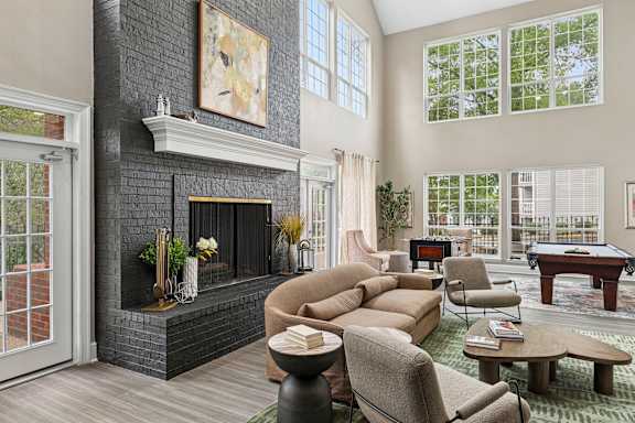 A living room with a fireplace and a pool table.